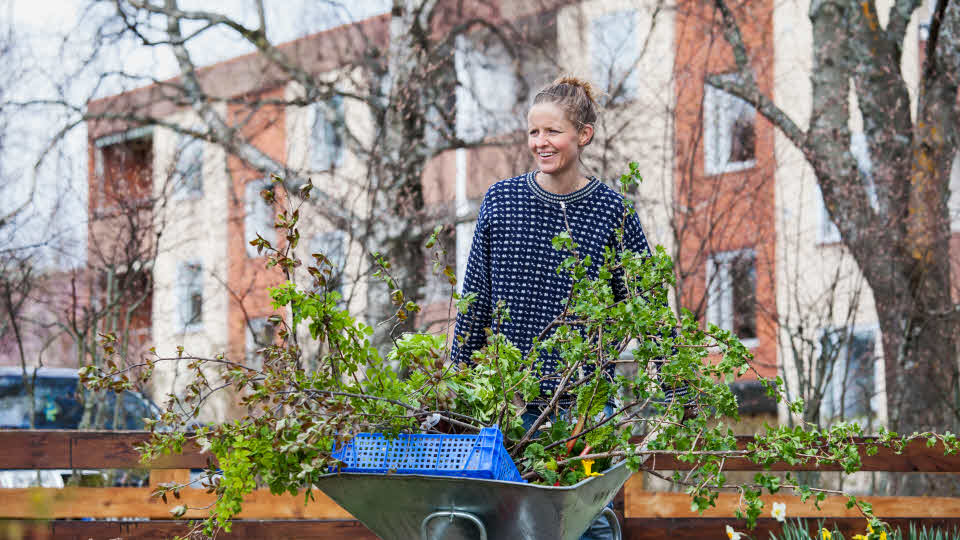 Kvinna med skottkärra i flerbostadsområde, Västervik.