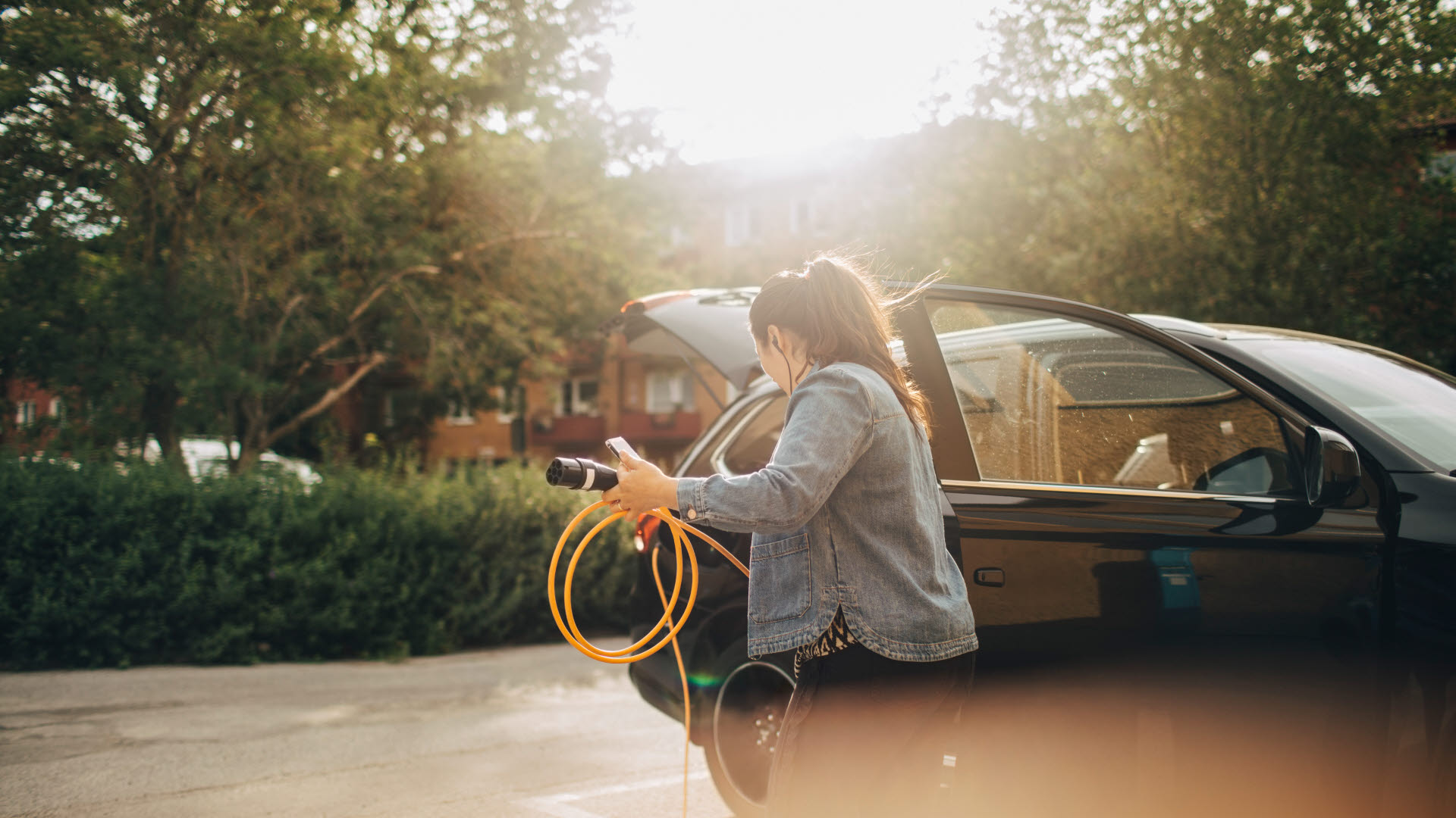 Fotograf: Maskot bildbyrå
Bildbyrå: Johnér Kvinna som ska ladda sin elbil vid garageuppfart