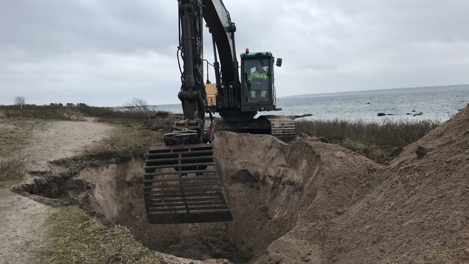 Grävmaskin på strand